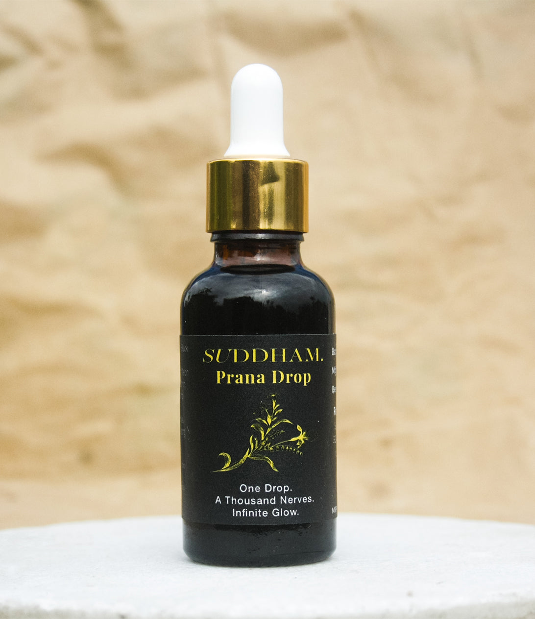 Suddham Prāṇa Drop luxury Ayurvedic navel oil in black and gold bottle with dropper.