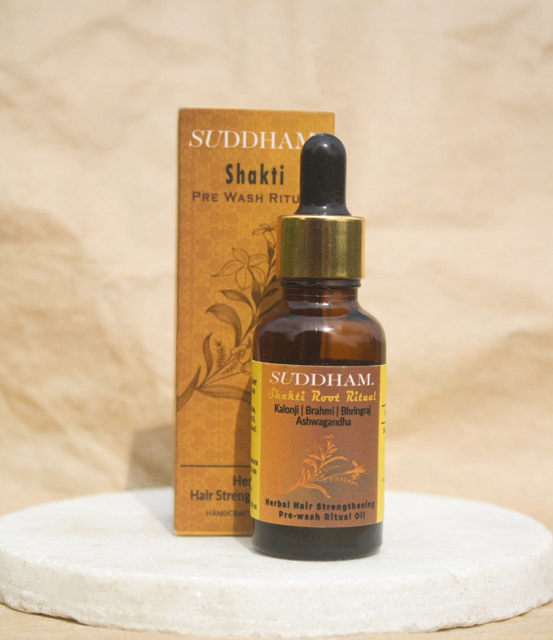 Suddham Shakti Hair Oil bottle with Ayurvedic box featuring golden herbal motif.